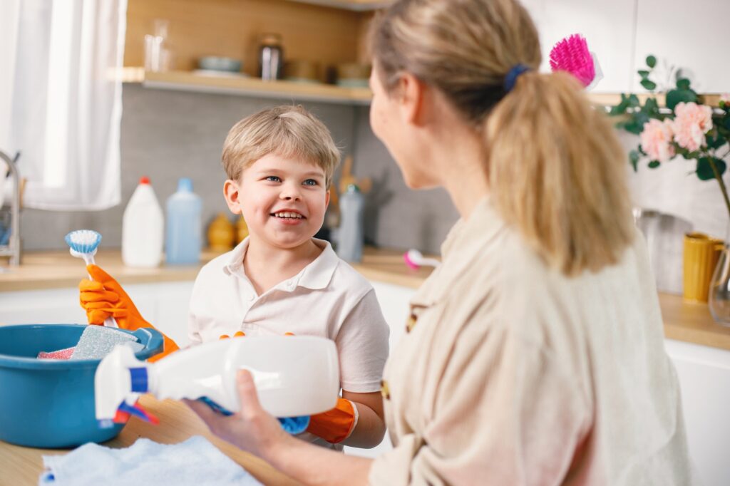 boy and woman acting like a cleaning company clean the table of a preschool in scottsdale az