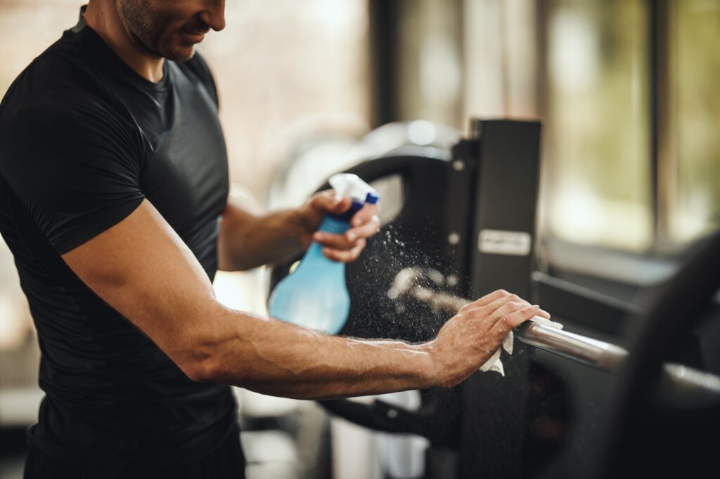 a man from a commercial cleaning company is at a gym fitness center and is wiping down the equipment in gilbert