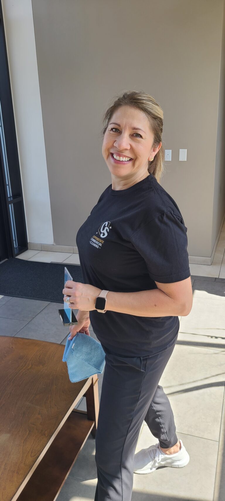 Woman smiling while cleaning an office in Phoenix Arizona